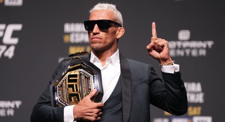 Charles Oliveira poses on stage at the UFC 274 press conference